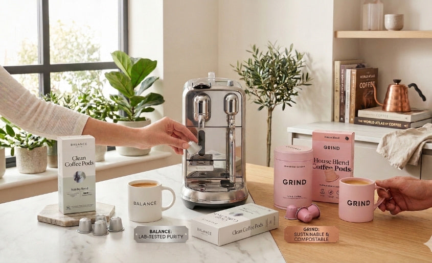 Grind vs Balance coffee pods comparison with espresso machine, showing compostable pods and lab-tested aluminium capsules side by side
